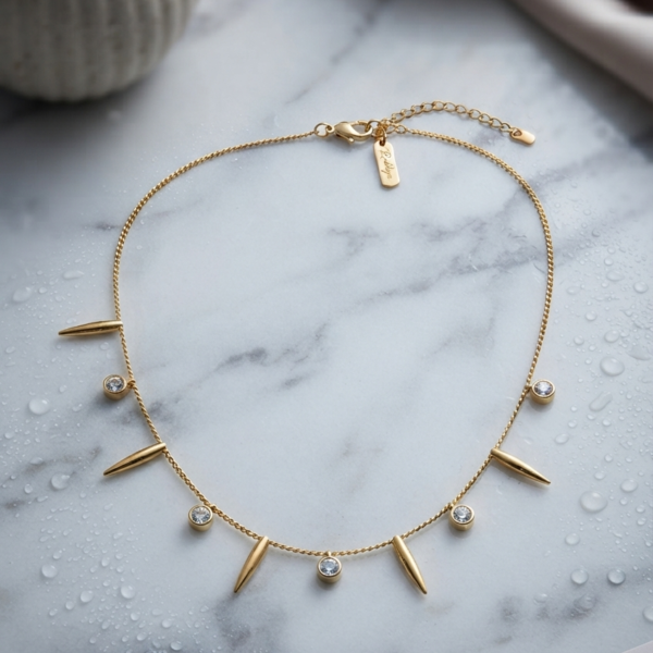 Gold chain with spiked and stone charms