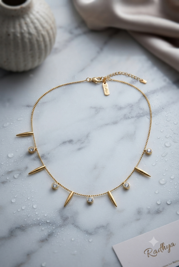 Gold chain with spiked and stone charms