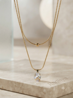 Layered gold snake chain with solitaire pendant.