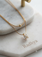 Layered gold snake chain with pear solitaire pendant.
