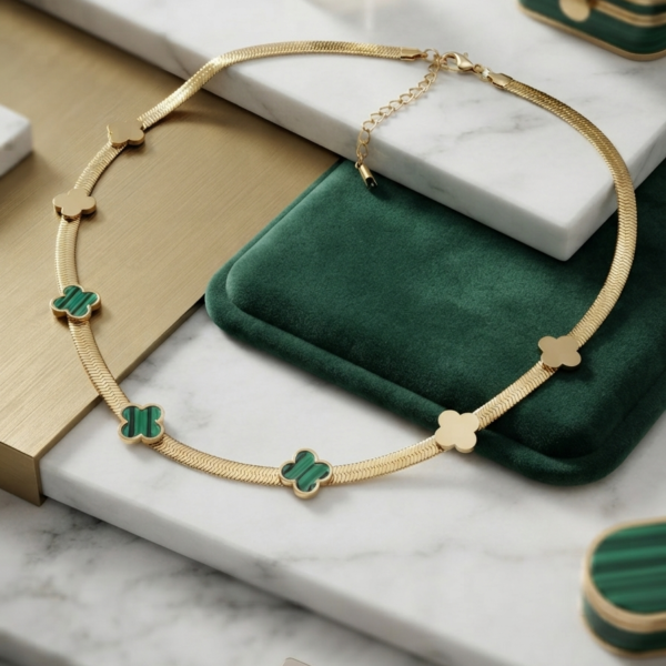 Gold snake chain with green clover motifs