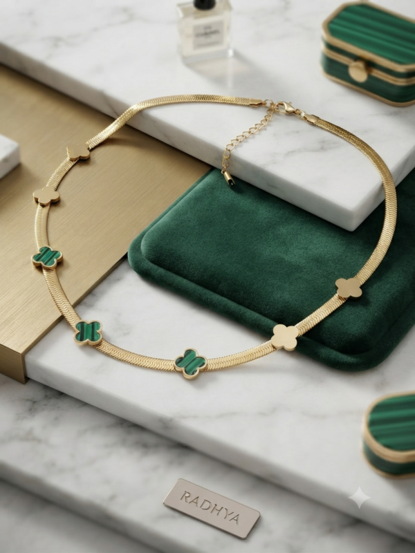 Gold snake chain with green clover motifs